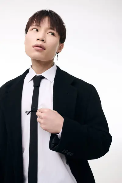 A young handsome asian man showcases his stylish attire with confidence, exuding charm. — Stock Photo