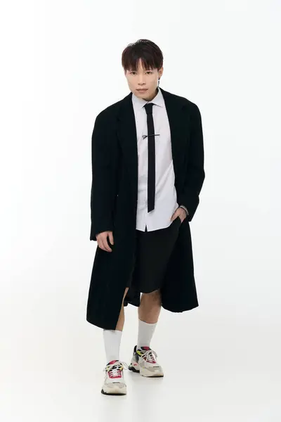 A young asian man steps forward, wearing a stylish ensemble that showcases modern trends and flair. — Stock Photo