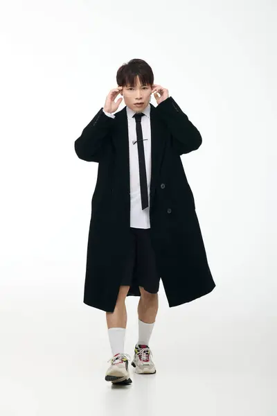 A young, stylish man interacts confidently against a minimalist background. — Stock Photo