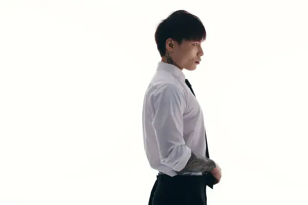 Sharp dressed young man with tattoos exuding charisma and elegance against a minimal backdrop. — Stock Photo