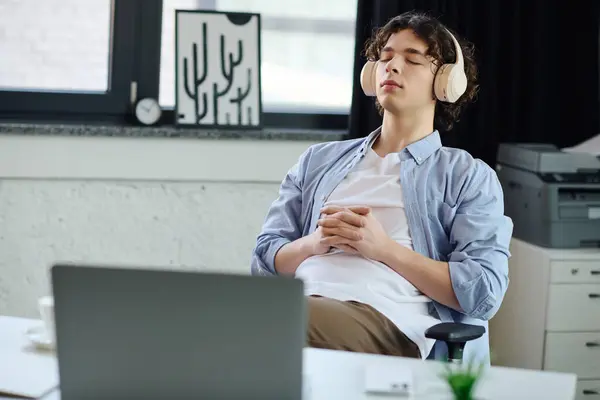 A young man relaxes with headphones in a stylish office. — Stock Photo