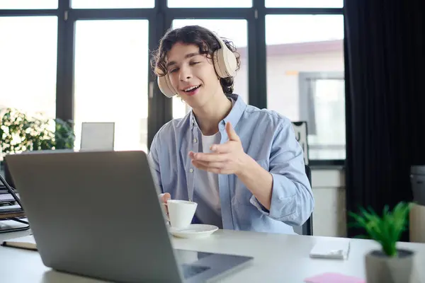 Young handsome professional actively discussing ideas while sipping coffee in a bright office. — Stock Photo