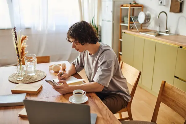 Bright office setting features a handsome young man focused on his tasks while sipping coffee. — Stock Photo