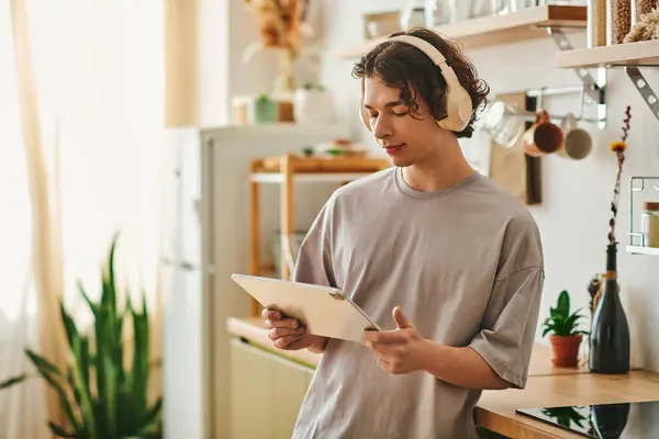 A handsome young man in a modern office setting is reading on a tablet and unwinding. — Stock Photo