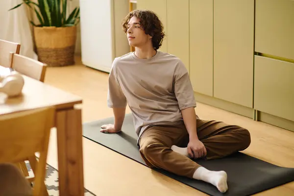 Young man relaxes on a yoga mat in a bright, cheerful office. — Stock Photo