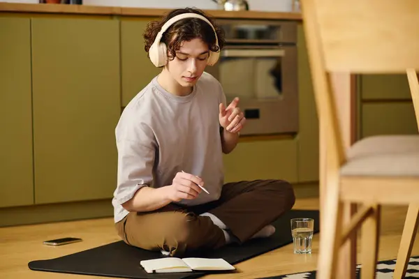 Attractive young man works on a mat in a stylish kitchen. — Stock Photo
