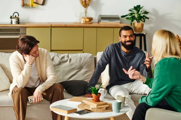 Three diverse young men enjoy lively discussions while relaxing in a stylish and cozy living room. — Stock Photo