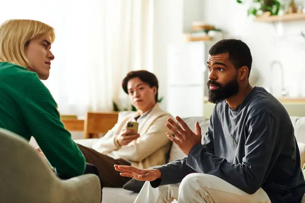 Three young men share ideas and connect during an engaging discussion at home. — Stock Photo