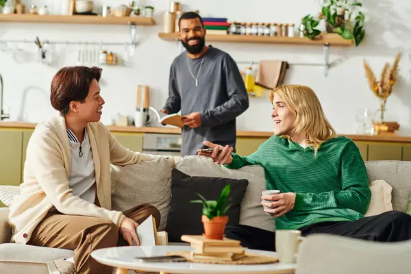 Drei gut aussehende junge Männer versammeln sich in einem stilvollen, gemütlichen Wohnzimmer zu lebhaften Diskussionen über Bücher.. — Stockfoto