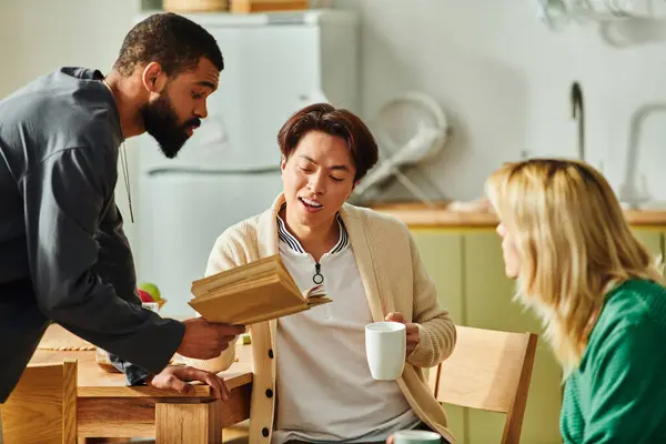 La belleza se encuentra con el intelecto mientras los hombres jóvenes se unen a los libros, compartiendo ideas y risas en casa. - foto de stock