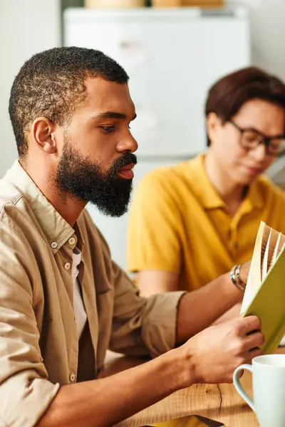 Young men enjoy meaningful conversations while reading together in a relaxed setting at home. — Stock Photo