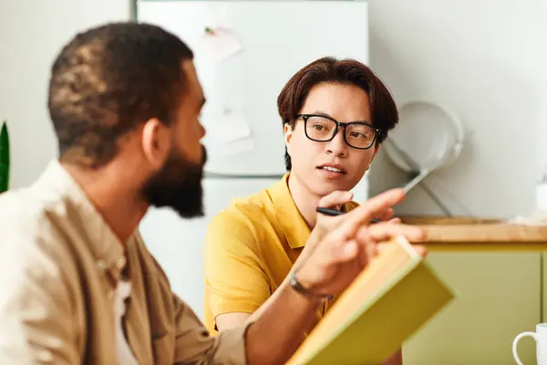 Zwei stylische junge Männer teilen Ideen und Beobachtungen während einer engagierten Buchclub-Sitzung zu Hause. — Stockfoto