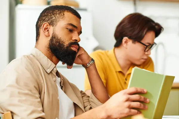 Young men bond over literature and engage in thoughtful conversation in a warm setting. — Stock Photo
