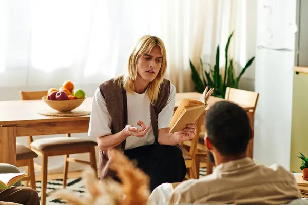 Young men engage in a lively discussion at their home book club, sharing thoughts on literature. — Stock Photo
