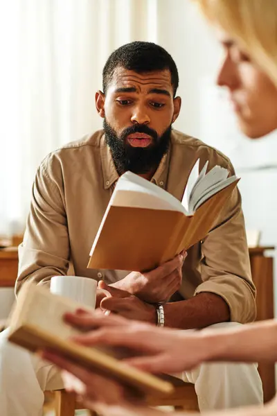 Young men gather at home for a casual book club, sharing insights and engaging in conversation. — Stock Photo