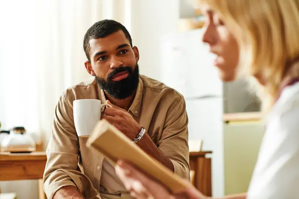 Young men enjoy deep conversations while savoring books and warm drinks in a relaxed setting. — Stock Photo