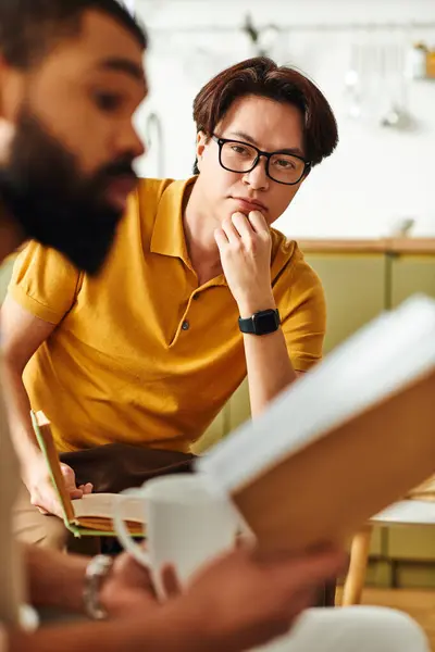 Young men participate actively in a lively discussion during their book club meeting at home. — Stock Photo