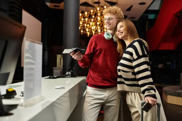 Ein verliebtes Paar checkt in einem trendigen Hotel ein und teilt Lächeln und Lachen, während sie gemeinsam die Gegend erkunden. — Stockfoto