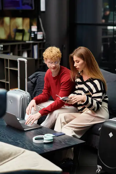 Loving couple engages in planning their adventures while relaxing in a chic hotel lounge. — Stock Photo