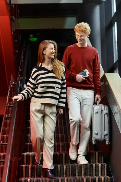 Pareja cariñosa camina de la mano por las escaleras del hotel, compartiendo sonrisas alegres y momentos de unión. — Stock Photo