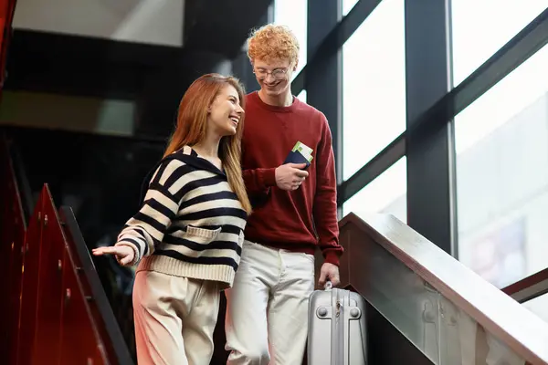 Una coppia condivide sorrisi e gioia mentre arrivano al loro hotel, pronti per una vacanza memorabile. — Foto stock