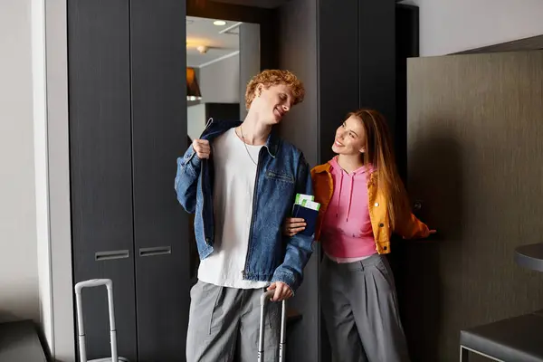 A young couple shares a loving glance while preparing for their stay at a modern hotel. — Stock Photo