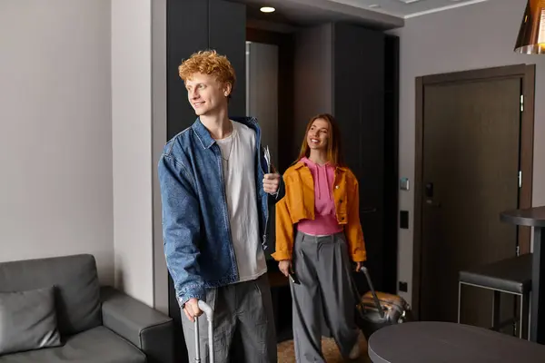 Joyful couple explores their chic hotel room, embracing love and excitement together. — Stock Photo