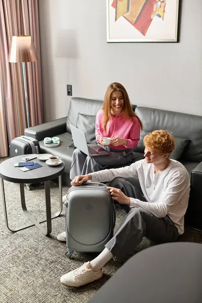 A loving couple enjoys their stay in a warm hotel atmosphere, bonding over travel preparations. — Stock Photo