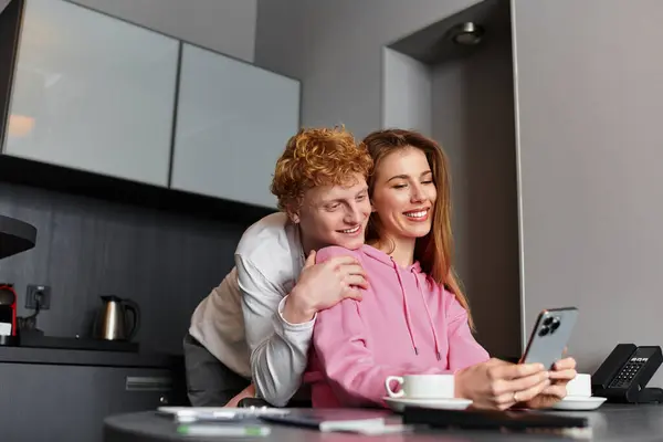 A loving young couple relaxes in their hotel room, enjoying each others company and laughter. — Stock Photo