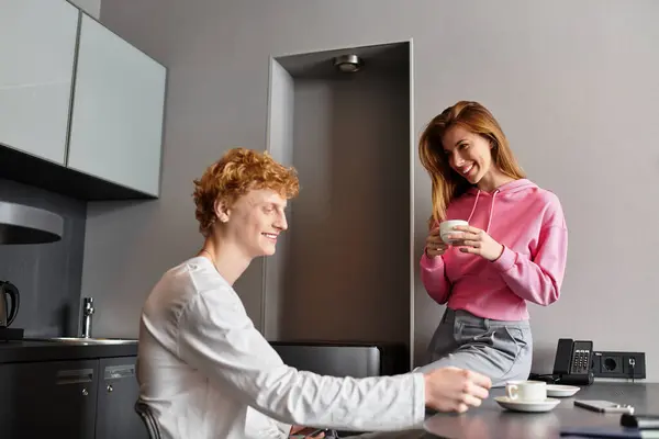 A young couple shares laughter and warmth while embracing each other in a cozy hotel room. — Stock Photo