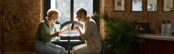 A middle aged man and woman share a delightful moment in a charming cafe, banner — Stock Photo