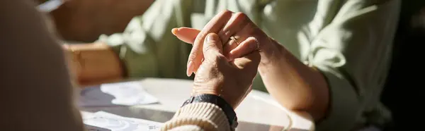 A middle-aged man and woman hold hands across the table, enjoying a romantic dinner together, banner — Stock Photo