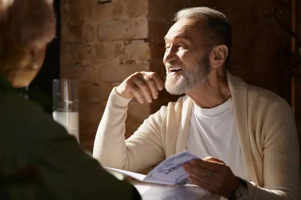 A middle-aged couple share laughter and conversation as they savor a romantic dinner together. — Stock Photo