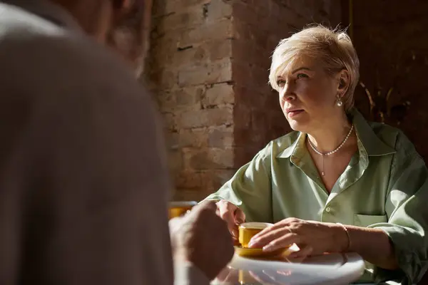 A middle aged couple enjoys a romantic date, engaging in deep conversation — Stock Photo