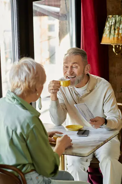 Middle aged couple shares an intimate moment over drinks while enjoying each others company. — Stock Photo