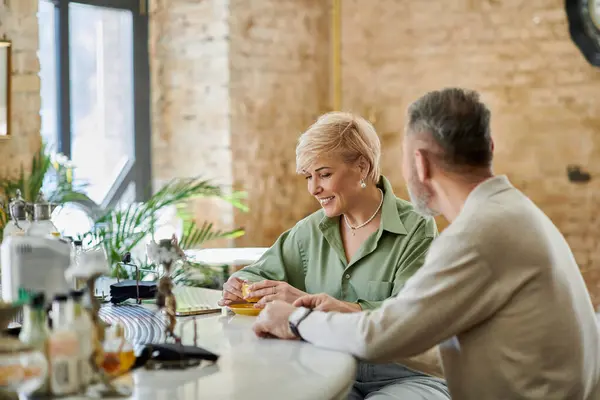 A joyful couple shares laughter while sipping drinks at a stylish bar, enjoying their date. — Stock Photo