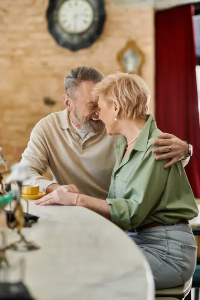 Ein Paar mittleren Alters verbringt einen zarten Moment an der Bar und genießt die Gesellschaft des jeweils anderen in Liebe. — Stockfoto