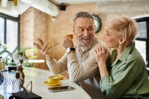 Mann mittleren Alters teilt einen verspielten Moment mit seiner Partnerin beim Kaffeetrinken. — Stockfoto