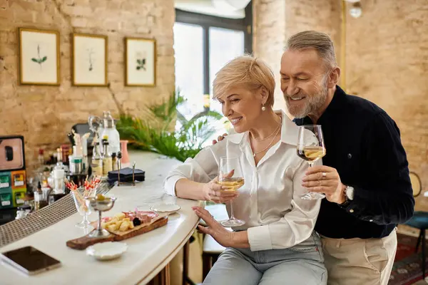 Mature couple enjoys drinks together at a charming restaurant, sharing laughter and affection. — Stock Photo