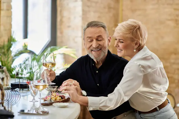 A mature couple shares a joyful moment over a delicious meal adorned with delicacies together. — Stock Photo