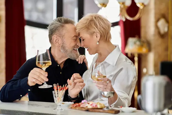 A middle-aged couple enjoys a joyful evening with laughter and drinks at a cozy cafe. — Stock Photo
