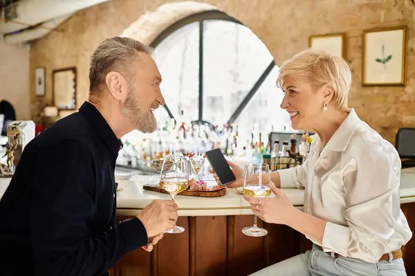 A lovely couple shares smiles while sipping drinks during a charming evening date. — Stock Photo