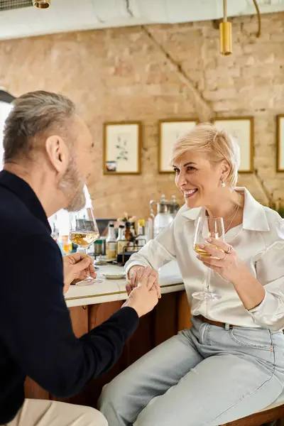 Mature couple shares a romantic moment while sipping drinks at an inviting bar. — Stock Photo