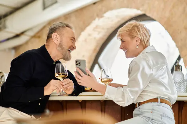 A mature couple enjoys each other's company while sipping drinks at a cozy bar. — Stock Photo