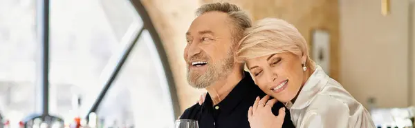 A middle aged couple enjoys each others company in a cozy bar, sharing smiles and laughter, banner — Stock Photo