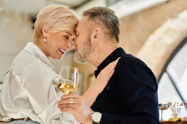 A happy couple leans in, sharing laughter over drinks in an intimate moment. — Stock Photo