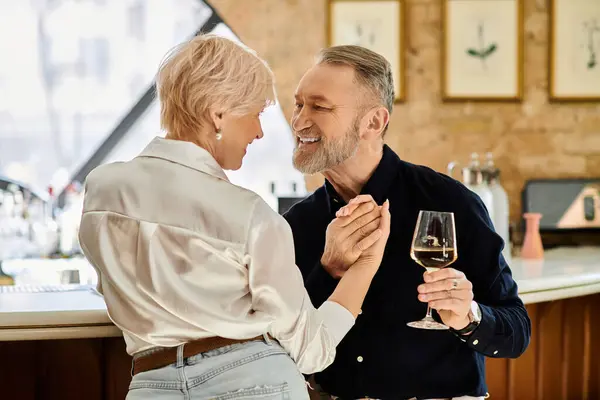 Ein Mann und eine Frau mittleren Alters genießen einen besonderen Moment, während sie gemeinsam ihre Drinks genießen. — Stockfoto