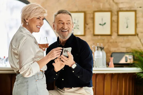 Um casal de meia idade desfruta de sua data em um bar elegante, rindo e compartilhando conversas doces. — Fotografia de Stock