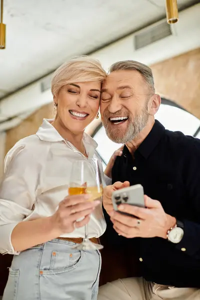 Ein Paar mittleren Alters teilt Lachen und Drinks bei einem herrlichen Date am Abend in einer gemütlichen Bar. — Stockfoto
