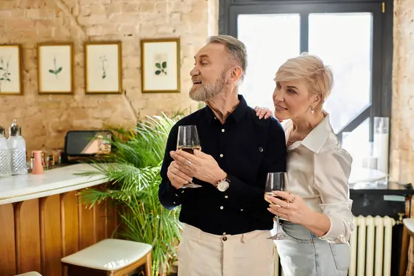 Ein bezauberndes Paar, das mit Wein anstößt, während es einen freudigen Moment in einem schönen Rahmen teilt. — Stockfoto